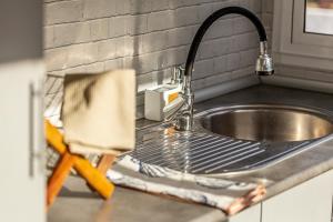 a kitchen sink with a metal strainer next to it at Casa das Flores by Hostiva in Aroeira +56 photos