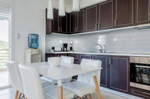 a kitchen with a white table and white chairs at Paliouri Villas in Paliouri +5 photos