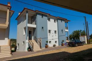 a white building with a car parked in front of it at Paliouri Villas in Paliouri