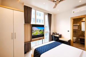 a bedroom with a bed and a tv in a room at Hotel Shri Govindam Banaras with Parking in Varanasi