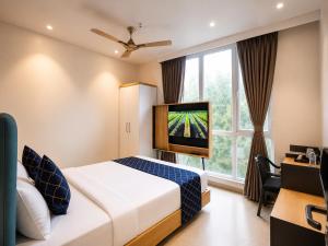 a hotel room with a bed and a tv at Hotel Shri Govindam Banaras with Parking in Varanasi