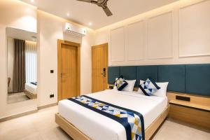 a bedroom with a large bed with a blue headboard at Hotel Shri Govindam Banaras with Parking in Varanasi