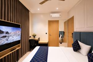a hotel room with a bed and a flat screen tv at Hotel Shri Govindam Banaras with Parking in Varanasi +38 photos