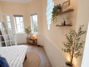 a room with a bed and a tree in it at Thềm Homestay in Da Thien