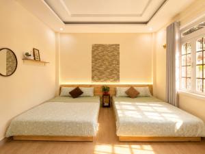 two beds in a room with two windows at Thềm Homestay in Da Thien +13 photos