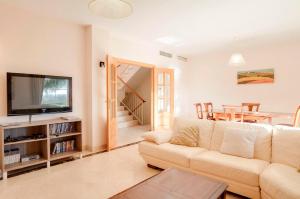 a living room with a couch and a tv at Villa Pilar in Mijas Costa