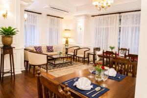 a dining room and living room with a table and chairs at Dhavara Boutique Hotel in Vientiane