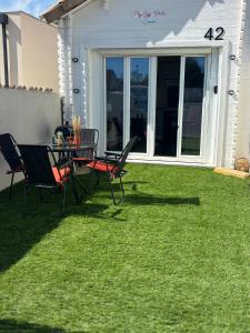 a patio with a table and chairs on the grass at Flyby pole studio in Béziers