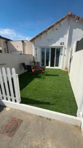 a backyard with a fence and a table on the grass at Flyby pole studio in Béziers