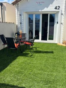a patio with a table and chairs on the grass at Flyby pole studio in Béziers +2 photos