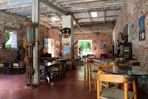 a restaurant with brick walls and tables and chairs at hotel florita in Jacmel