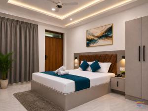 a bedroom with a large bed with blue pillows at Hotel Shanti Residency Vrindavan in Vrindāvan +71 photos
