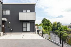 a black house with a balcony with a view at Fujiyama Stay101 in Fujinomiya