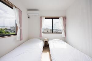 two beds in a small room with a window at Fujiyama Stay101 in Fujinomiya