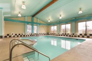 a large swimming pool with chairs around it at Comfort Inn Ebensburg in Ebensburg