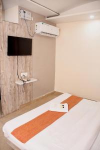 a room with two beds and a flat screen tv at Hotel J P Residency in Datia +16 photos