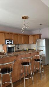 a kitchen with a counter and three bar stools at Near ASA Arena Circus in Ulaanbaatar