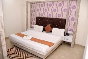 a bedroom with a large bed with a purple wall at Hotel J P Residency in Datia