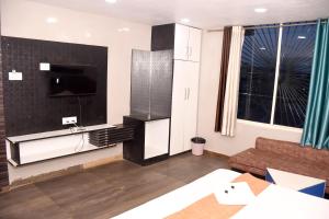a living room with a couch and a flat screen tv at Hotel J P Residency in Datia