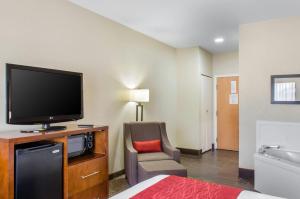 a hotel room with a television and a chair at Comfort Inn & Suites Covington - Mandeville in Covington
