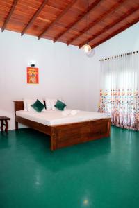 a bed in a room with a green floor at Circle Edge Resort in Kandy
