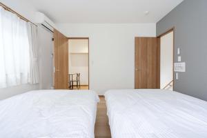a bedroom with two beds and a window at Fujiyama Stay102 in Fujinomiya