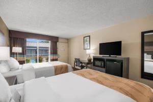 a hotel room with two beds and a flat screen tv at Quality Inn Concord Kannapolis in Concord +37 photos