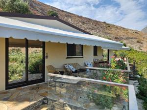 a house with a balcony with a table and chairs at Aria's Apartment 1 in Qeparo