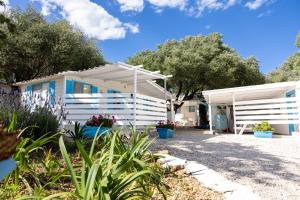 a white house with trees in the background at Camping Car Palmasera in Cala Gonone