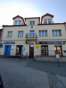 a large white building with a sign in front of it at Apartament Karmelicka in Wadowice