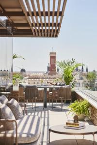 a rooftop patio with tables and chairs and a view of the city at Thompson Madrid, by Hyatt in Madrid