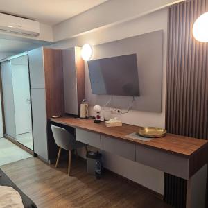 a hotel room with a desk with a television on it at CHARLOTTE STUDIOS BY BLAXY RESORT Olimp in Olimp