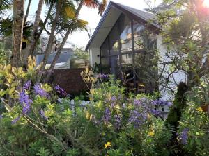a garden with purple flowers in front of a house at The 1954 House in Da Lat