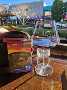 a glass of wine sitting on a table next to a book at Vibrant & Vintage B & B in Greenmount +49 photos