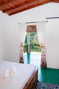 a bedroom with a bed with curtains and a green floor at Circle Edge Resort in Kandy