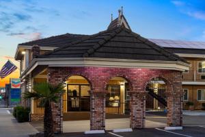 a brick building with an archway in a parking lot at Ramada Bayside Inn & Suites Eureka in Eureka