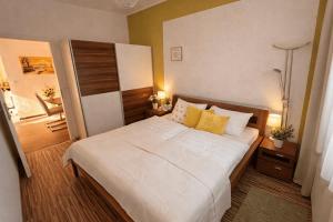 a bedroom with a large white bed with yellow pillows at Ferienwohnungen Gutenbrunn in Gutenbrunn
