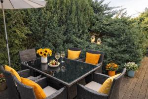 a patio with a table and chairs with yellow pillows at Ferienwohnungen Gutenbrunn in Gutenbrunn