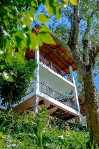 a tree house with a balcony on top of it at Circle Edge Resort in Kandy
