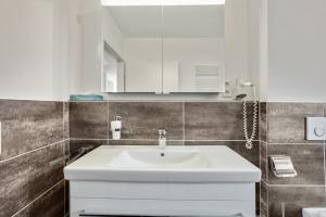 a bathroom with a white sink and a mirror at Ferienwohnung Landblick im Markgräflerland mit kostenlosem Parkplatz in Bad Bellingen +19 photos