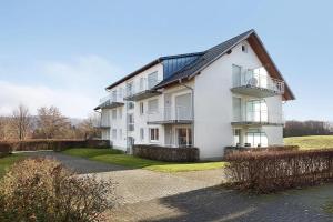 a large white building with balconies and a driveway at Ferienwohnung Landblick im Markgräflerland mit kostenlosem Parkplatz in Bad Bellingen