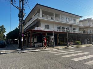 a woman walking down a street in front of a building at Hermes Studio in Paralia Katerinis