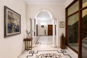 a hallway with an archway in a home with white walls at FabHotel The Arjun Sushant lok - Iffco Chowk Sector 29 in Gurgaon