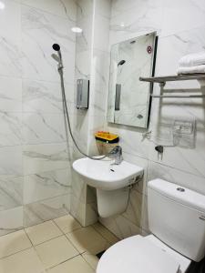 a white bathroom with a toilet and a sink at 倆倆民宿 in Donggang +18 photos