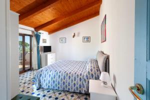 a bedroom with a bed with a blue comforter at Gaiano Apt in Sorrento +119 photos