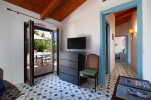 a room with a television and a chair and a table at Gaiano Apt in Sorrento