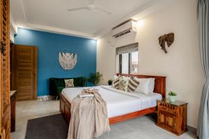 a bedroom with a bed and a blue wall at Go Offline Homes - Designer 2BHK with Pool Near Candolim in Parra +13 photos