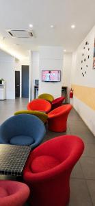 a waiting room with red and blue chairs at The Leverage Business Hotel - Rawang in Rawang +15 photos