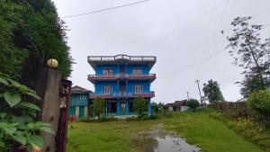 ein blaues Gebäude mitten in einem Hof in der Unterkunft Hotel Nigale in Dhankuta