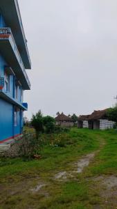 ein blaues Gebäude neben einer Wiese in der Unterkunft Hotel Nigale in Dhankuta